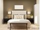 Well-lit bedroom featuring a upholstered headboard, bench, bedside tables, and coordinated decor at 4641 Potters Wheel Ct, Fort Mill, SC 29715