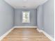 Bright bedroom features wood flooring, gray walls, and a window, creating a serene living space at 4924 Jane Ave, Charlotte, NC 28269