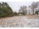 View of the large backyard with mature trees on a snow-covered lot at 5028 Wilgrove Mint Hill Rd, Mint Hill, NC 28227