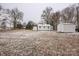 Large backyard with mature trees and a storage shed on a snow-covered lot at 5028 Wilgrove Mint Hill Rd, Mint Hill, NC 28227