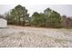 A view of the backyard with light snow dust with large mature trees in the background at 5028 Wilgrove Mint Hill Rd, Mint Hill, NC 28227