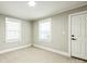 Bedroom with two windows and a door featuring neutral carpet, paint and trim at 5028 Wilgrove Mint Hill Rd, Mint Hill, NC 28227