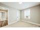 Bedroom featuring neutral carpet, paint and trim, with window and door at 5028 Wilgrove Mint Hill Rd, Mint Hill, NC 28227