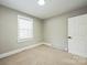 Bedroom featuring neutral carpet, paint and trim, with a window and a door at 5028 Wilgrove Mint Hill Rd, Mint Hill, NC 28227