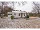Quaint white home with covered carport and landscaped yard lightly dusted with snow on an overcast day at 5028 Wilgrove Mint Hill Rd, Mint Hill, NC 28227