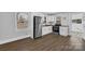 Bright kitchen showcasing stainless steel appliances, ample white cabinets, and wood-look flooring at 5028 Wilgrove Mint Hill Rd, Mint Hill, NC 28227