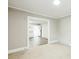Bright room with gray walls, white trim, carpeted floors, and an open doorway to the kitchen at 5028 Wilgrove Mint Hill Rd, Mint Hill, NC 28227