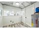 Bright utility room with wood-look floors, multiple windows, and modern water heater at 5028 Wilgrove Mint Hill Rd, Mint Hill, NC 28227