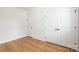 Bright bedroom featuring light hardwood floors, two closets, and fresh, neutral paint at 5404 Maplewood Ln, Charlotte, NC 28227