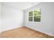 Sunlit bedroom showcasing a large window and light hardwood floors at 5404 Maplewood Ln, Charlotte, NC 28227