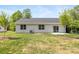 Back of a gray single-story home featuring a dark roof, small patio, and a grassy lawn at 5404 Maplewood Ln, Charlotte, NC 28227