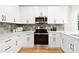 Bright kitchen with stainless appliances, stone countertops, and sleek white cabinetry at 5404 Maplewood Ln, Charlotte, NC 28227