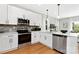 Bright kitchen featuring stainless steel appliances, white cabinetry, and a stylish backsplash at 5404 Maplewood Ln, Charlotte, NC 28227