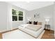 A serene main bedroom with a large window, hardwood floors, and modern decor at 5404 Maplewood Ln, Charlotte, NC 28227