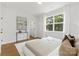 Sunlit main bedroom with a large window, hardwood floors, and stylish decor elements at 5404 Maplewood Ln, Charlotte, NC 28227