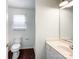 Bathroom featuring a toilet, sink and mirror, and a window at 5610 Stone Bluff Ct, Charlotte, NC 28214