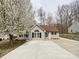 Inviting single-story home with a large front yard with mature tree, a well-manicured lawn and extended driveway at 5610 Stone Bluff Ct, Charlotte, NC 28214