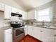 Well-lit kitchen features white cabinets, stainless steel appliances, and granite countertops at 5610 Stone Bluff Ct, Charlotte, NC 28214