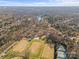 Expansive aerial view featuring sports fields, a tranquil lake, and a residential neighborhood surrounded by lush trees at 701 S Torrence St, Charlotte, NC 28204