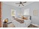 Cozy bedroom with a decorative ceiling fan, two bright windows and comfortable bedding at 701 S Torrence St, Charlotte, NC 28204