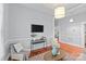 Cozy living room with warm hardwood floors, light blue walls, a ceiling light, and access to the kitchen at 701 S Torrence St, Charlotte, NC 28204