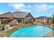 An exterior view of a luxurious backyard with a pool, brick home, and a screened-in porch at 894 Abilene Ln, Fort Mill, SC 29715