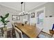Bright dining room features a modern chandelier, large wood table and sunlit windows at 894 Abilene Ln, Fort Mill, SC 29715