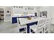 Gourmet kitchen features white cabinets, navy island, quartz countertops and a breakfast bar at 894 Abilene Ln, Fort Mill, SC 29715