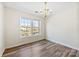 Inviting dining area filled with natural light, featuring hardwood floors and a chandelier at 1068 Plaza Walk Dr, Charlotte, NC 28215