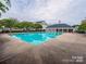 Large community swimming pool with surrounding lounge area and nearby clubhouse for residents' enjoyment at 1068 Plaza Walk Dr, Charlotte, NC 28215