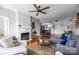 Open-concept living room with a fireplace, wood floors, and an adjoining kitchen space at 11576 Costigan Ln, Charlotte, NC 28277