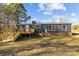 Charming exterior view of home with a wooden deck and stairs, surrounded by a grassy yard and blue sky at 1254 Raxter Rd, Edgemoor, SC 29712