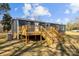 A shot of the house and the wooden deck with stairs, which provides lots of space for entertaining or just enjoying the outdoors at 1254 Raxter Rd, Edgemoor, SC 29712