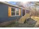 Lovely exterior view of home with wood shutters, blue siding, small porch, and fresh landscaping at 1254 Raxter Rd, Edgemoor, SC 29712
