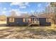 Single-story home with navy siding, wood shutters, white-trimmed windows, and a charming wooden front porch at 1254 Raxter Rd, Edgemoor, SC 29712