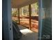 Covered outdoor patio with wood pillars and a view of the backyard and surrounding wooded area at 128 Summerlake Dr, New London, NC 28127