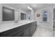 Bright bathroom featuring a double vanity with gray cabinets and a large mirror at 16709 Mckee Rd, Charlotte, NC 28278