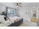 Bright bedroom with a ceiling fan, neutral carpet, and a large window at 16709 Mckee Rd, Charlotte, NC 28278