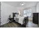 A well-lit bedroom with a bed with decorative pillows, side table, and views from the large window at 16709 Mckee Rd, Charlotte, NC 28278