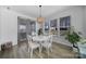 Bright breakfast nook with white table and chairs, pendant lighting and view of the landscaped yard at 16709 Mckee Rd, Charlotte, NC 28278