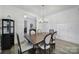 Bright dining room with stylish chandelier, wood floors and furniture, and white wainscoting at 16709 Mckee Rd, Charlotte, NC 28278