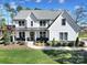 Beautiful two-story home with white siding, black trim, a manicured lawn and professional landscaping at 16709 Mckee Rd, Charlotte, NC 28278