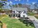 A beautiful white two-story home with a large lawn and driveway with basketball hoop on a sunny day at 16709 Mckee Rd, Charlotte, NC 28278