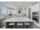 White gourmet kitchen with barstool seating at the oversized island, stainless steel appliances, and hardwood floors at 16709 Mckee Rd, Charlotte, NC 28278