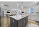 Kitchen island with barstool seating, pendant lights, hardwood floors and views to the living room at 16709 Mckee Rd, Charlotte, NC 28278