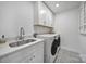 Well-lit laundry room featuring white cabinets, modern appliances, and a stylish sink at 16709 Mckee Rd, Charlotte, NC 28278