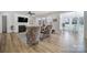 Living room with a fireplace, tv, light blue rug, hardwood floors, and a view into the breakfast nook at 16709 Mckee Rd, Charlotte, NC 28278