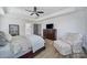 Neutral bedroom featuring a ceiling fan, wood floors, and a comfortable sitting area at 16709 Mckee Rd, Charlotte, NC 28278