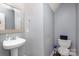 Half bathroom featuring a pedestal sink, decorative mirror, and neutral wall paint at 2444 Fabyan Ln, Charlotte, NC 28262