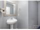 Cozy powder room features a sleek pedestal sink and a modern mirror at 2444 Fabyan Ln, Charlotte, NC 28262